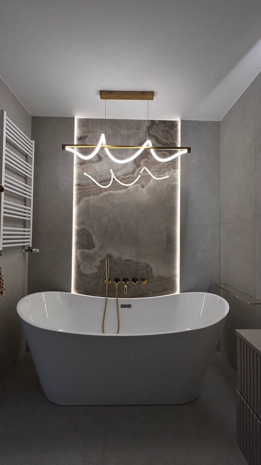 Łazienka z podświetlaną ścianą z onyksu, realizacja WIZJA Interior Design Studio